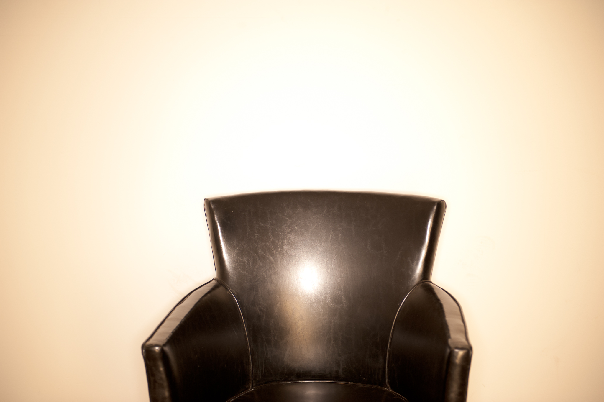 black leather chair ringflash white wall