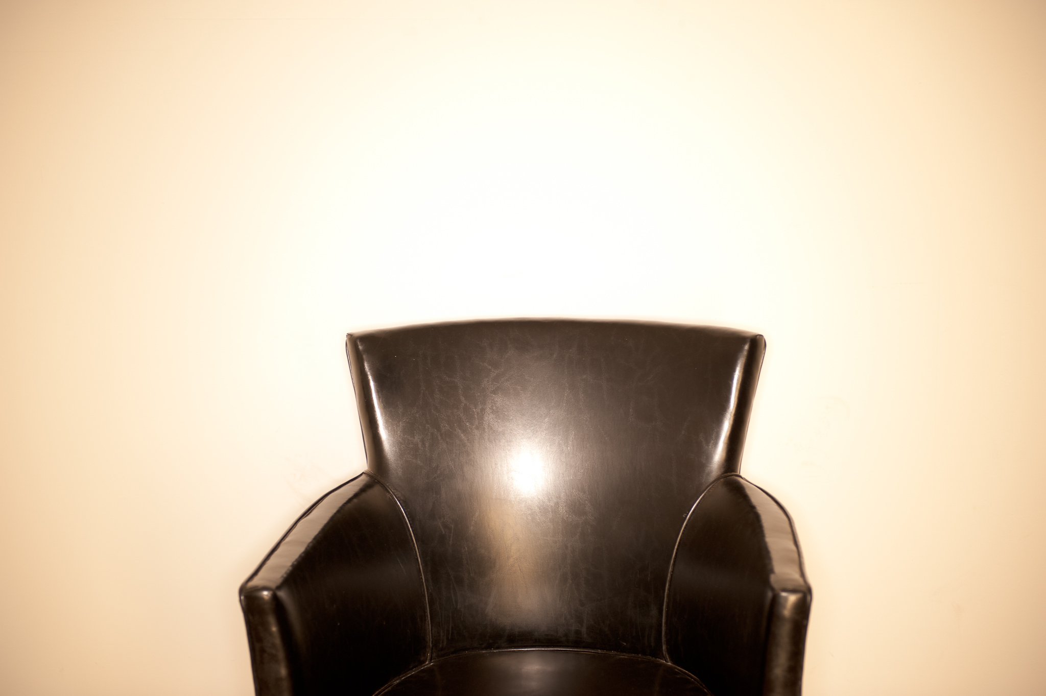 black leather chair ringflash white wall