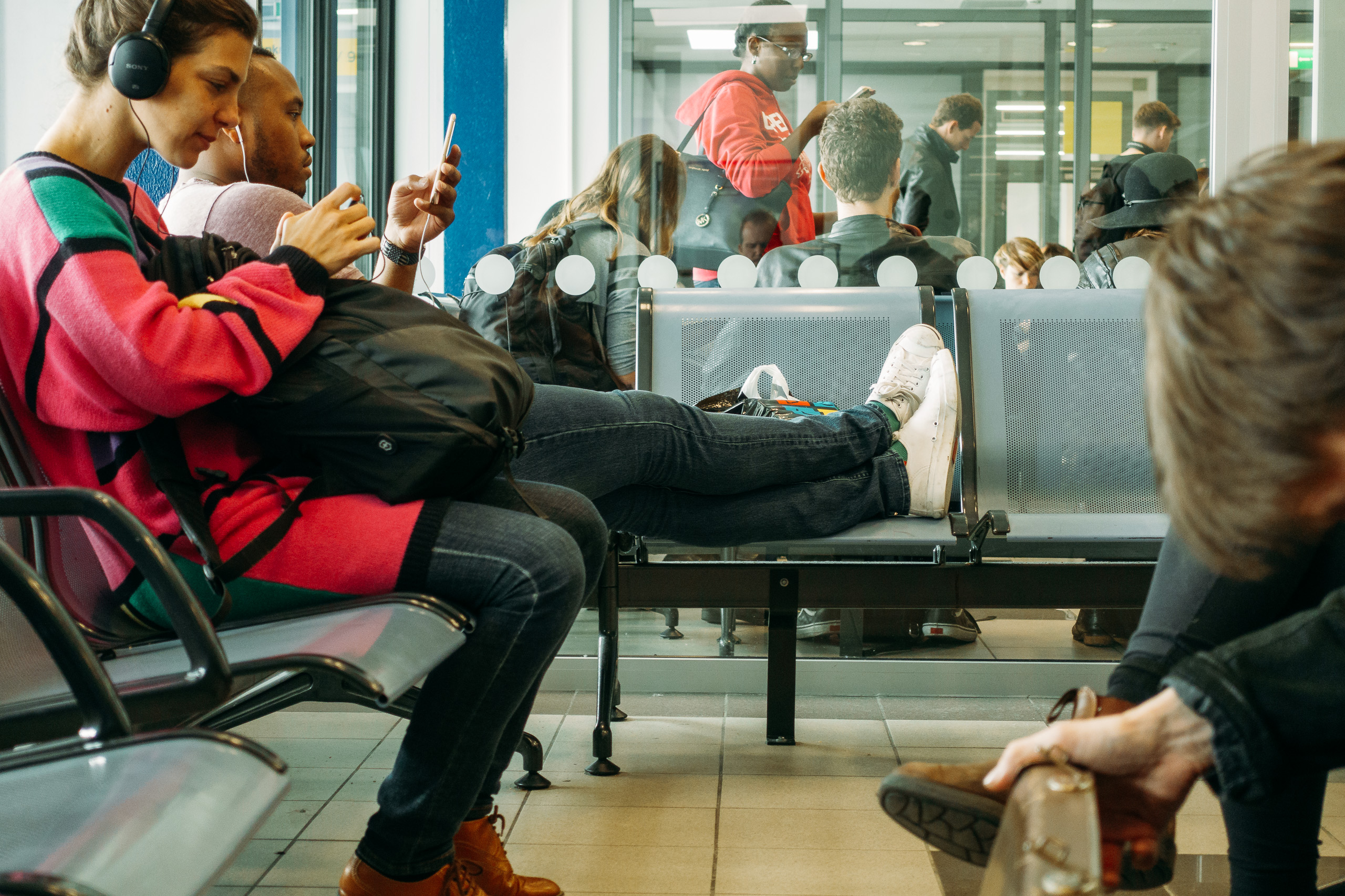 Disinterest in displacing others, an American props his feet upon a public seat.