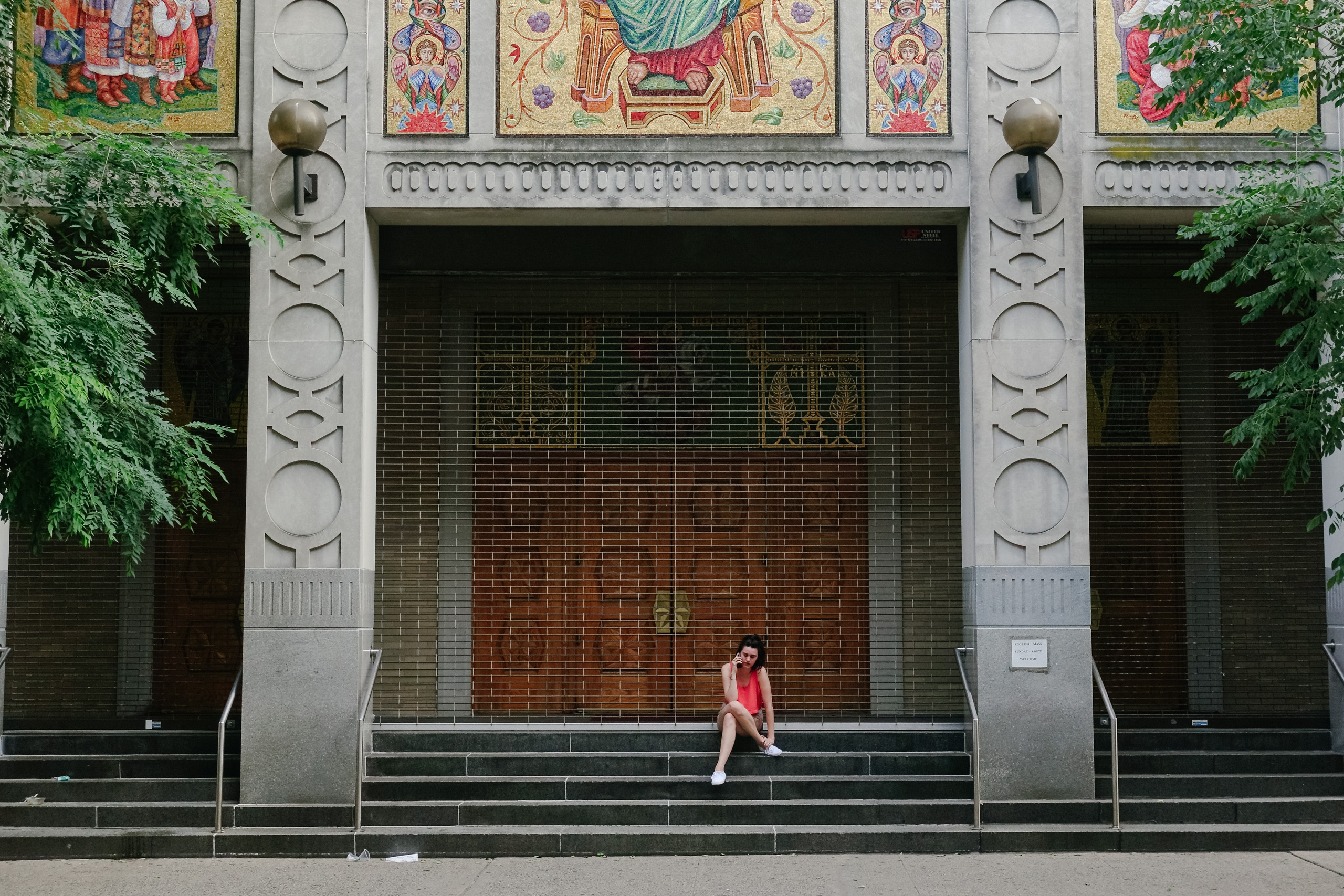 Young woman on the phone seated at the foot of the Lord