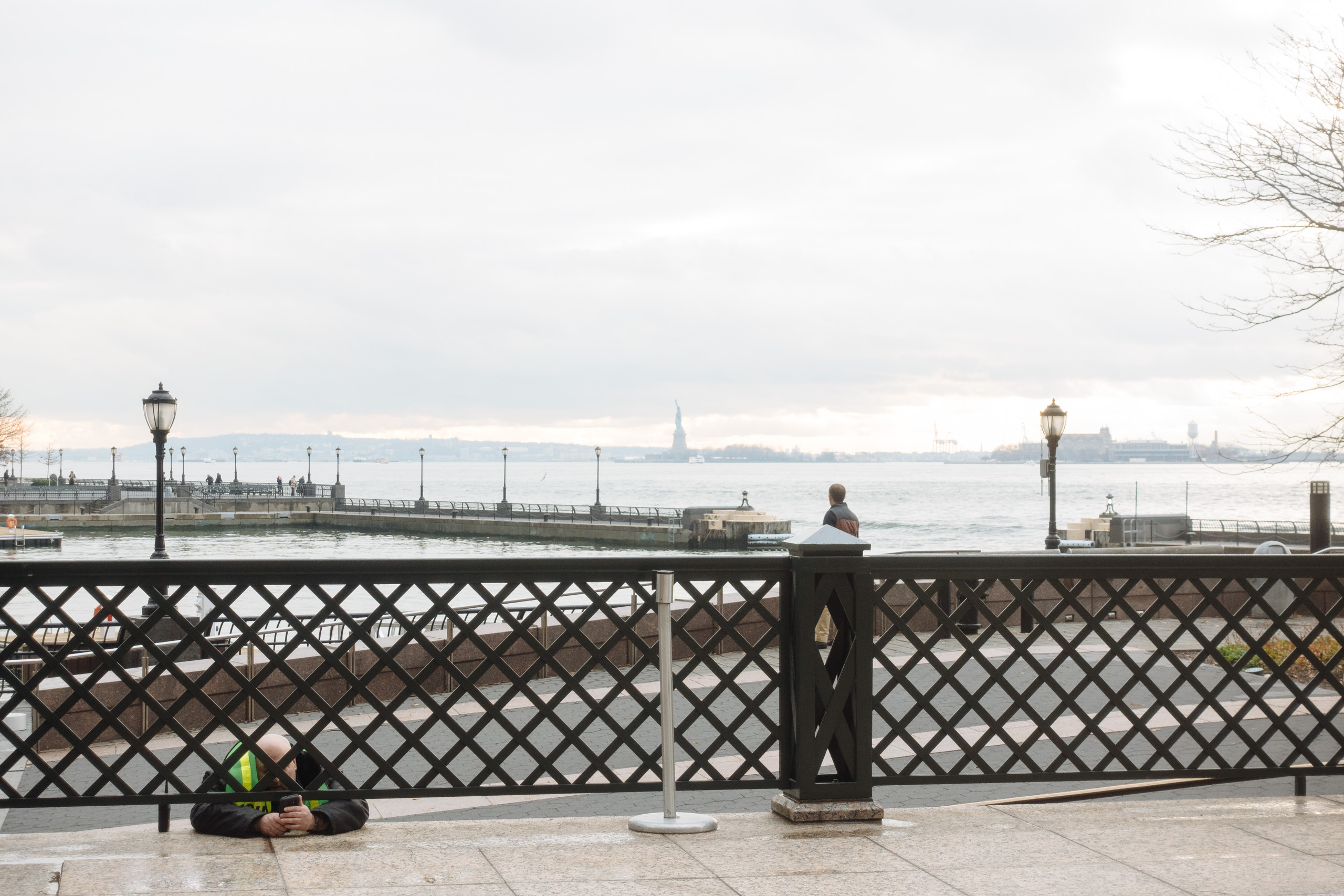 Security guard texts in the Battery Park Esplenade