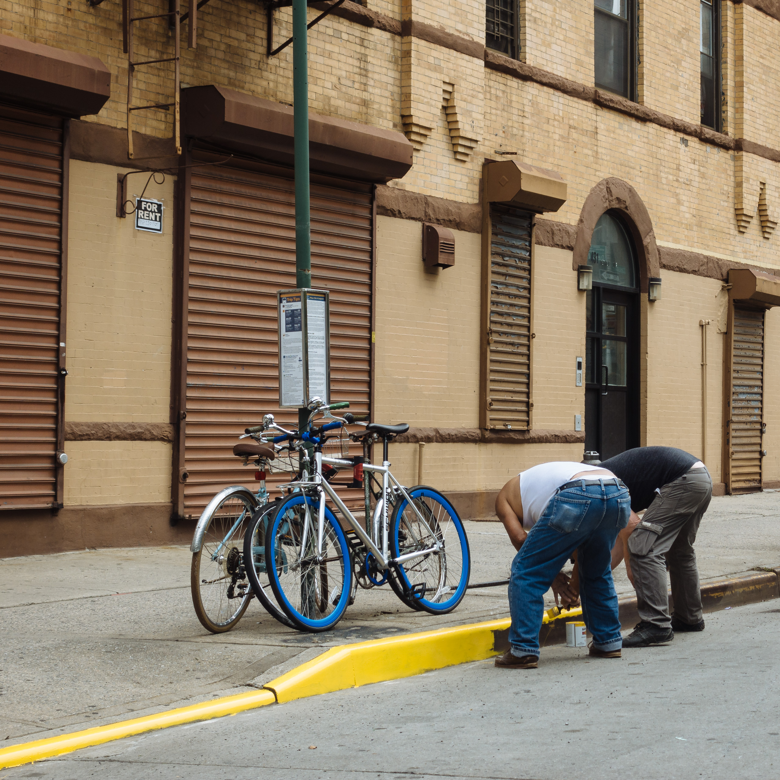 men painting curb in bed-stuy