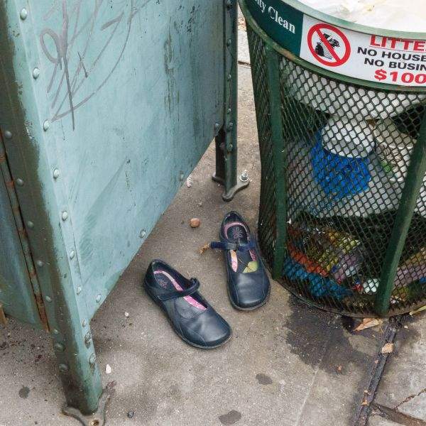 Shoes by a garbage can