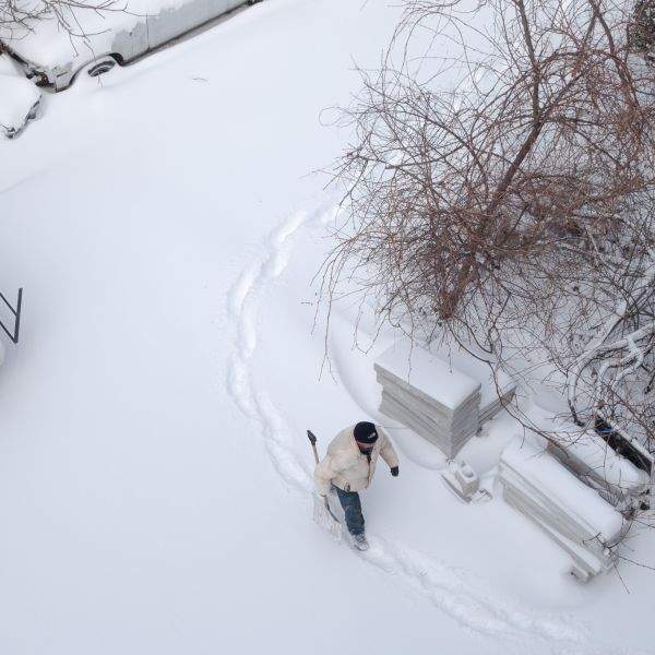 In the parking lot below, a man about to shovel snow