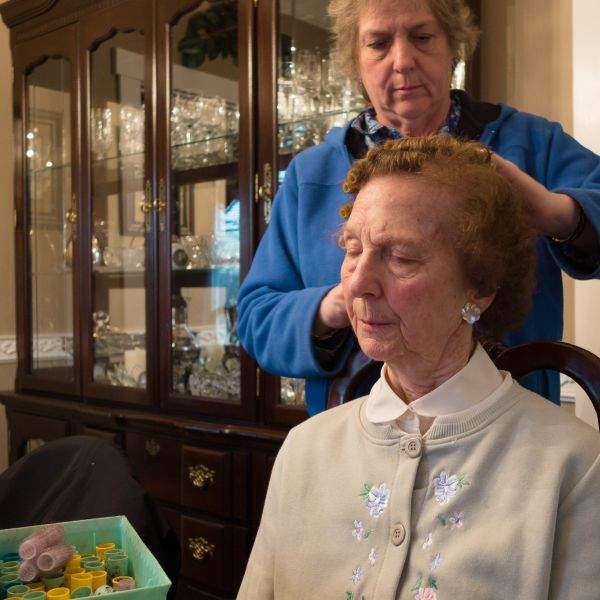woman helping mother put hair in rollers