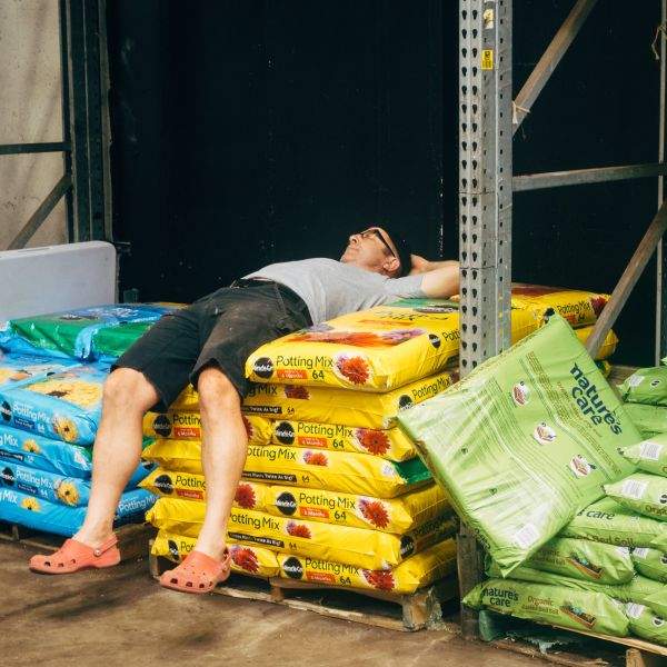 A man rests on a pile of potting mix