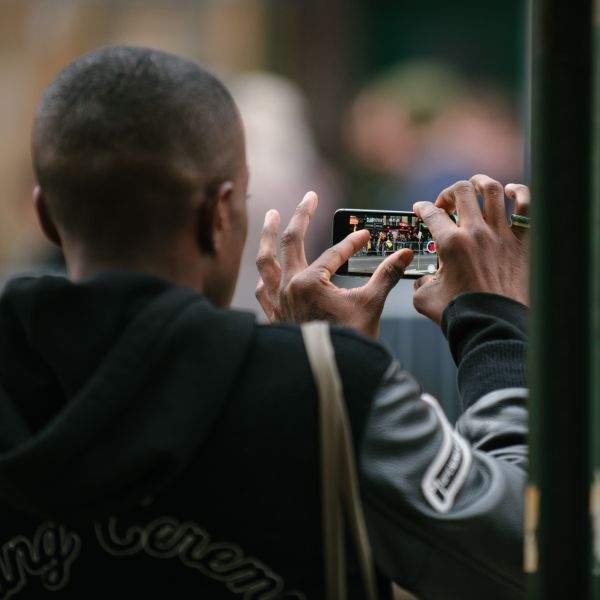 Man documenting the May Day March long 2nd Avenue