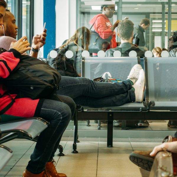 Disinterest in displacing others, an American props his feet upon a public seat.