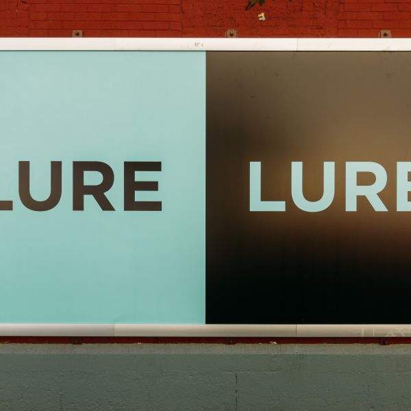 A street level &quot;Lure&quot; sign on a wall in Hudson Square