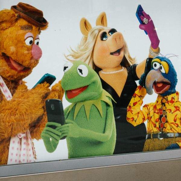 An advertiesment promoting the Muppet Show features recognizable Muppets operating smartphones