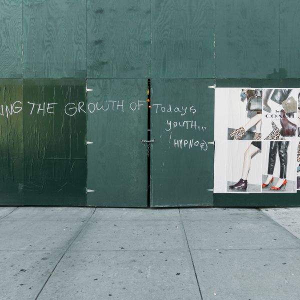 Signage and scrawl on a work site wall