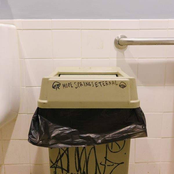 A trash bin in a men's room