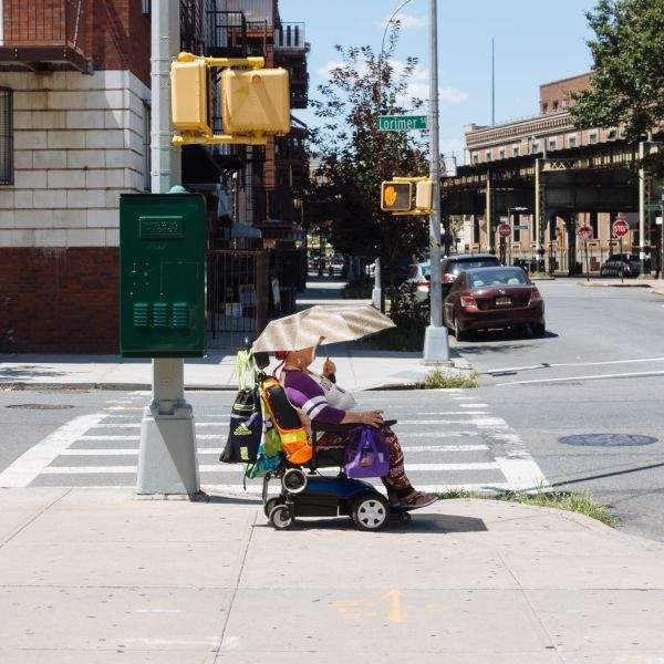 Woman in electric wheelchair with shade umbrella