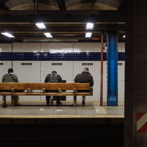 Men on a bench waiting for the train at Canal Street