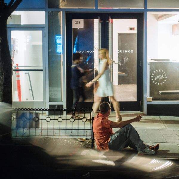 Man on curb, drunk, and leering.