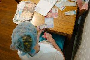 Grandma at the kitchen table, clipping coupons on a Saturday night
