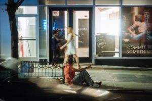 Man on curb, drunk, and leering.