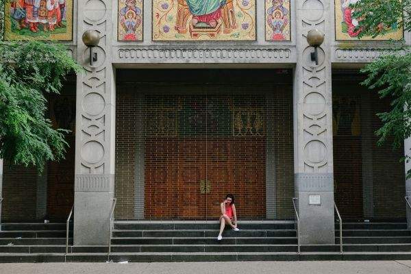 Young woman on the phone seated at the foot of the Lord