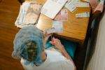 Grandma at the kitchen table, clipping coupons on a Saturday night