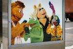An advertiesment promoting the Muppet Show features recognizable Muppets operating smartphones