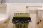 A trash bin in a men's room