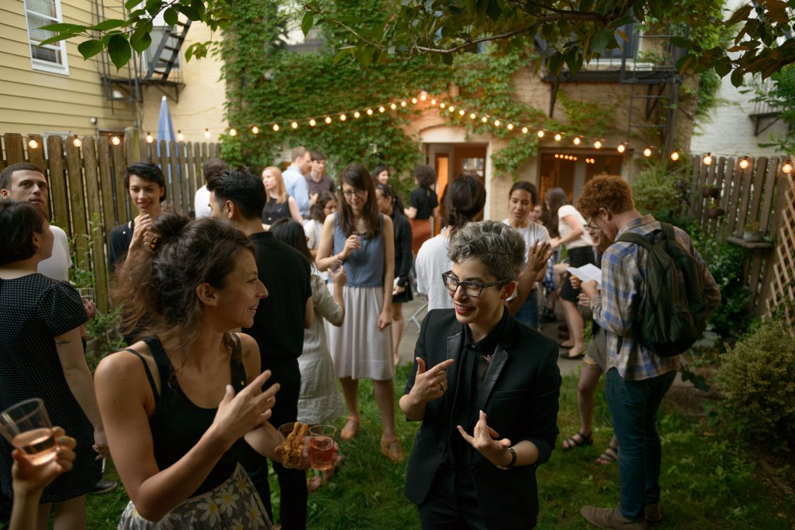 A growing number of guests gather and mingle outside.