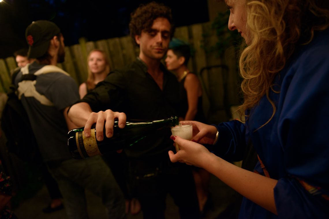 A man pours a drink for a guest.