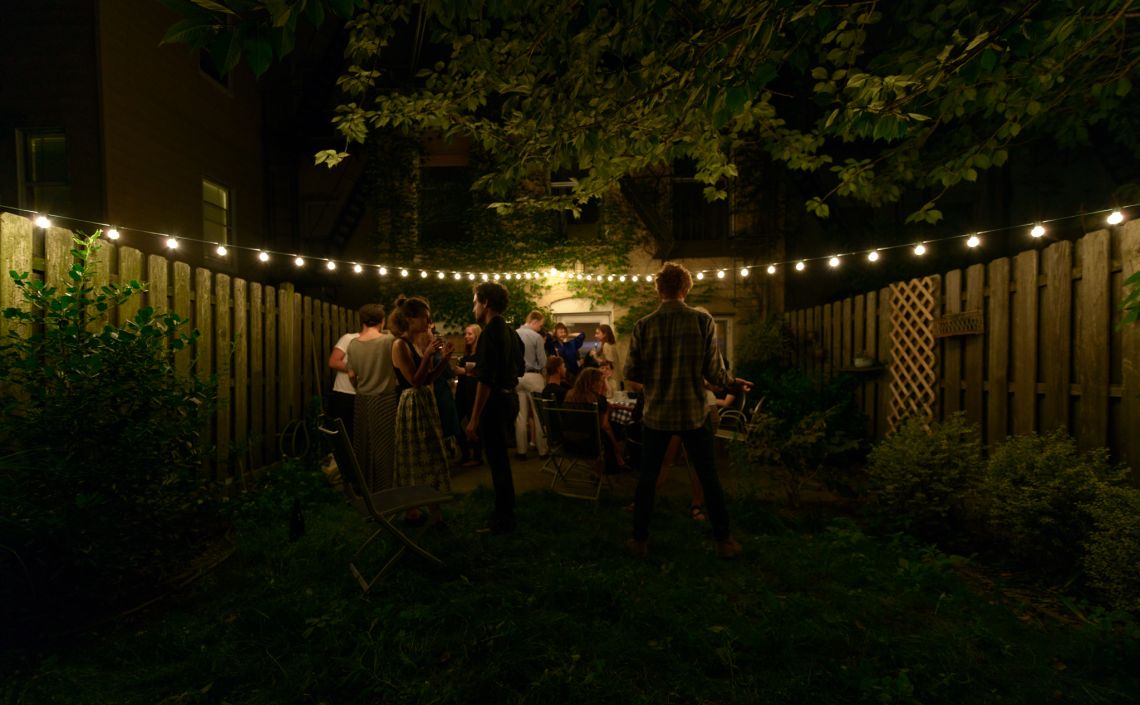 Guests continue mingling in the encroaching darkness of night