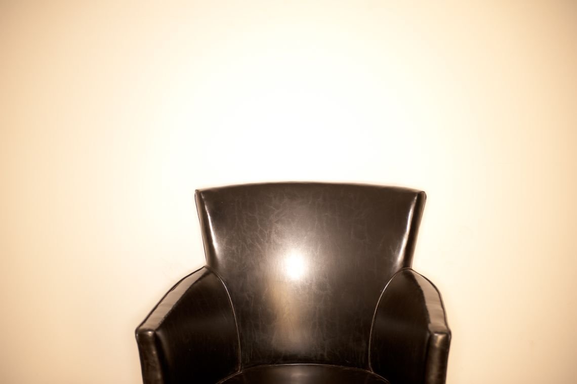 black leather chair ringflash white wall