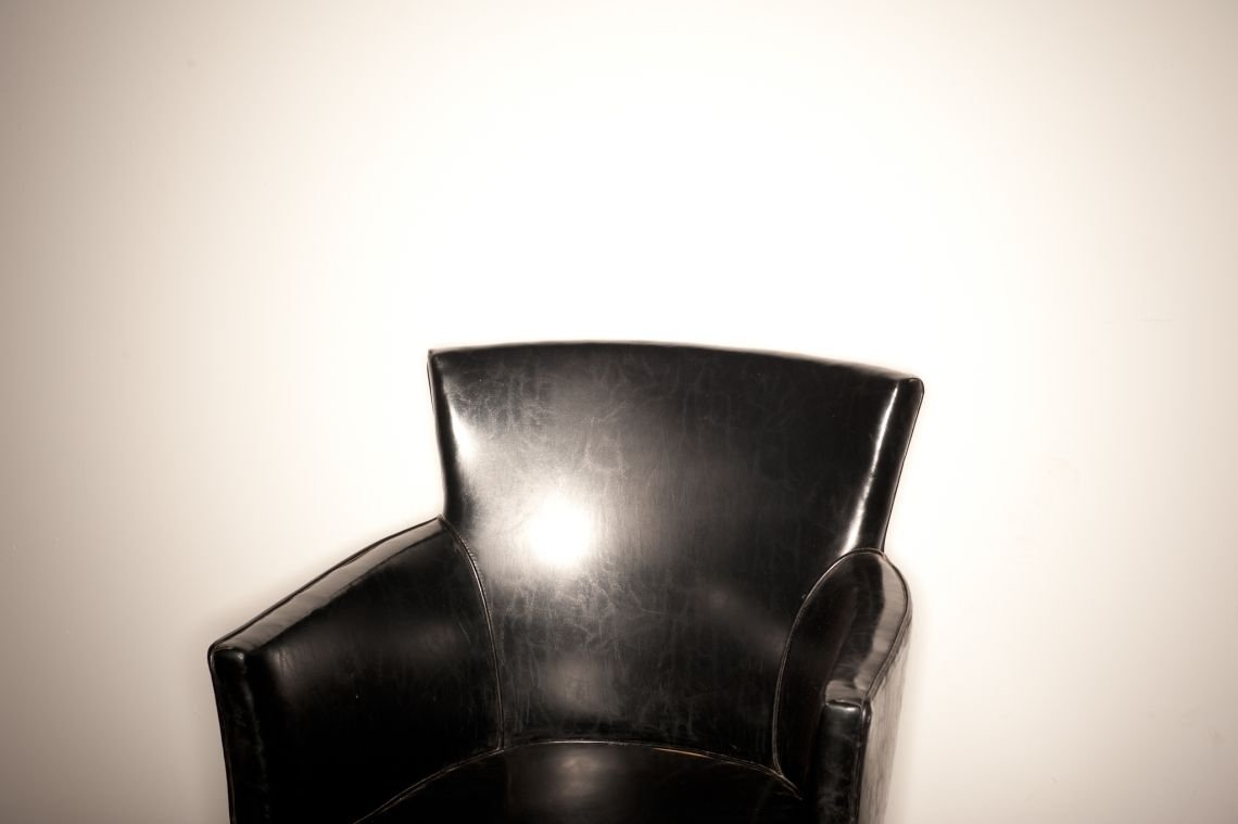 black leather chair ringflash white wall