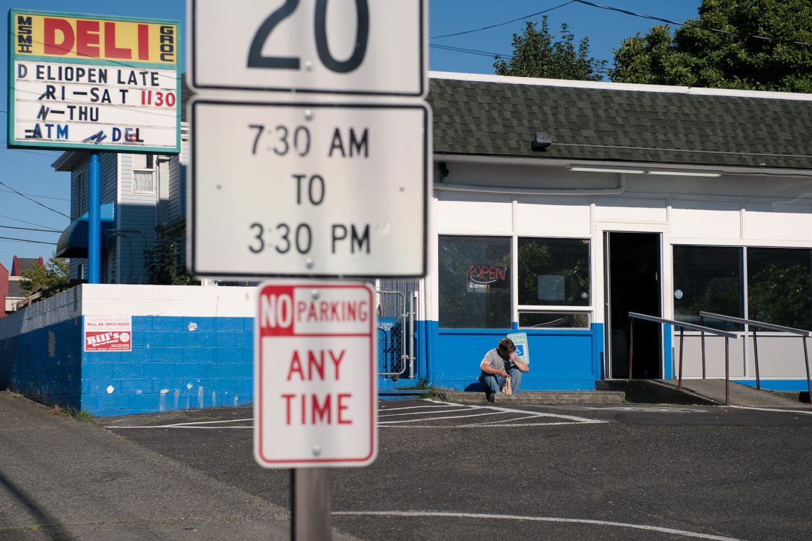 A man sits on a curb.