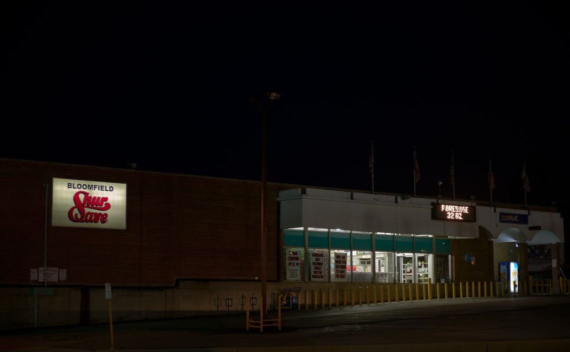 Grocery store storefront and parking lot at night
