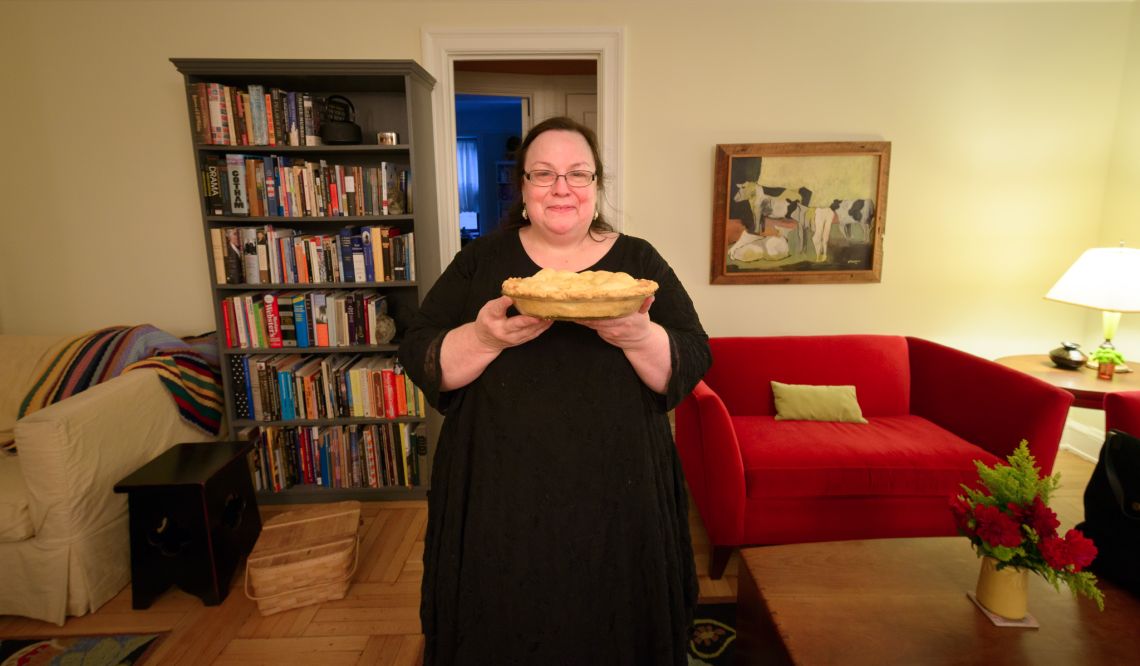 woman presenting a pie in an apartment