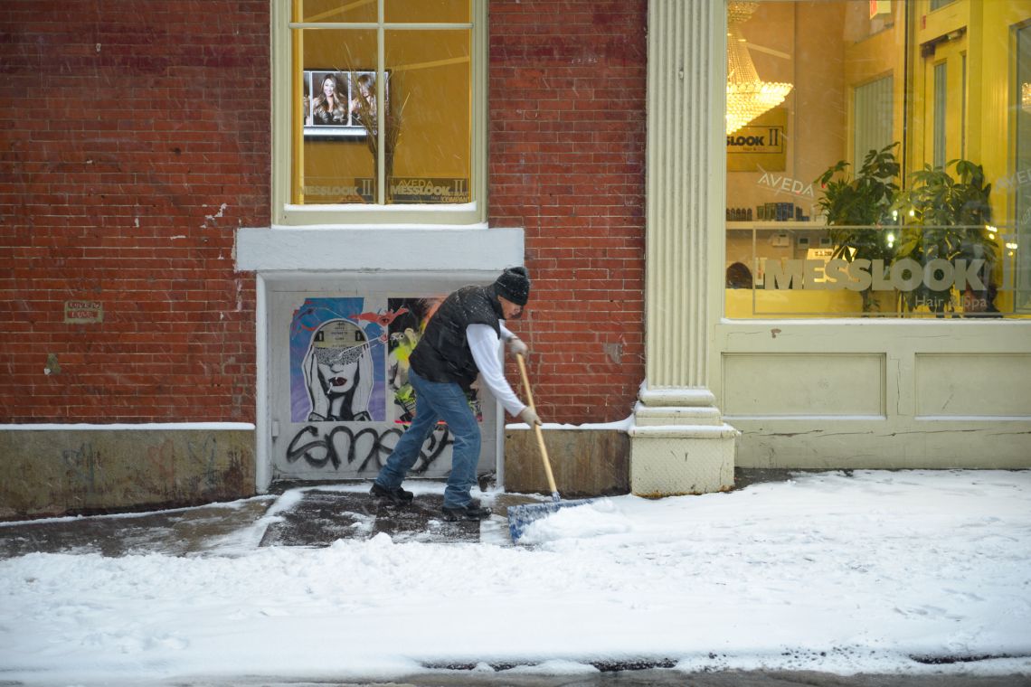 man shoveling snow in soho