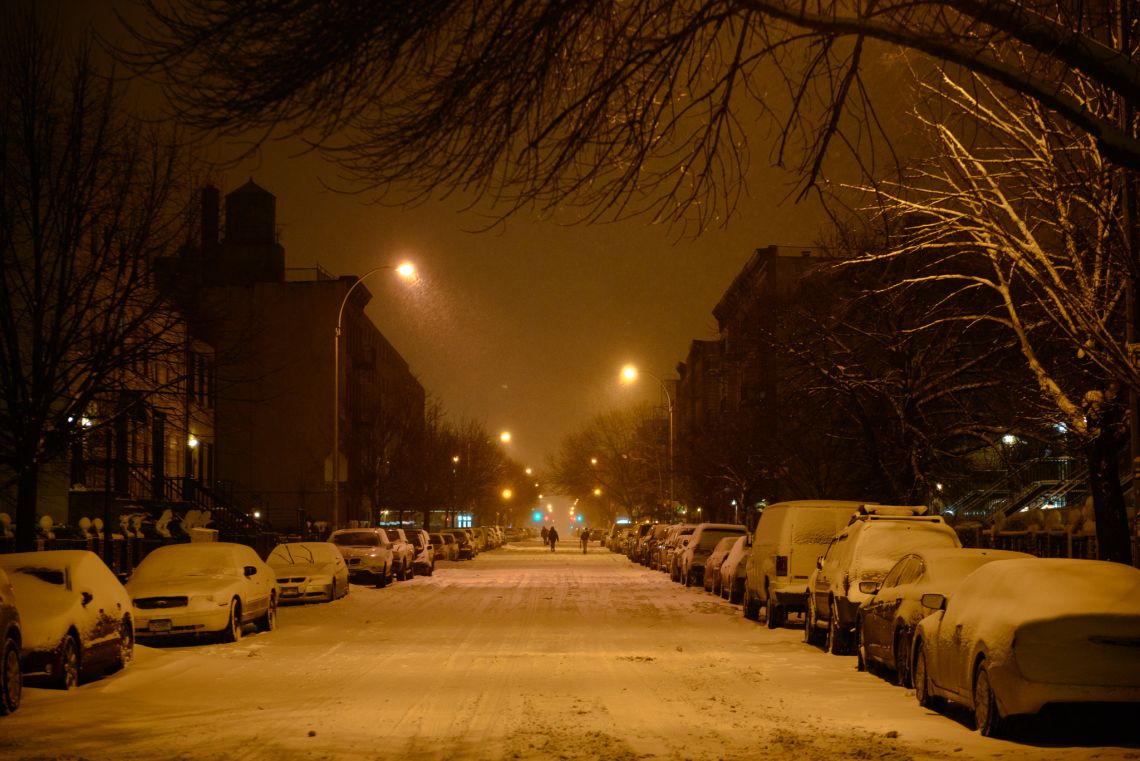 A handful of people walking on Gates Ave.