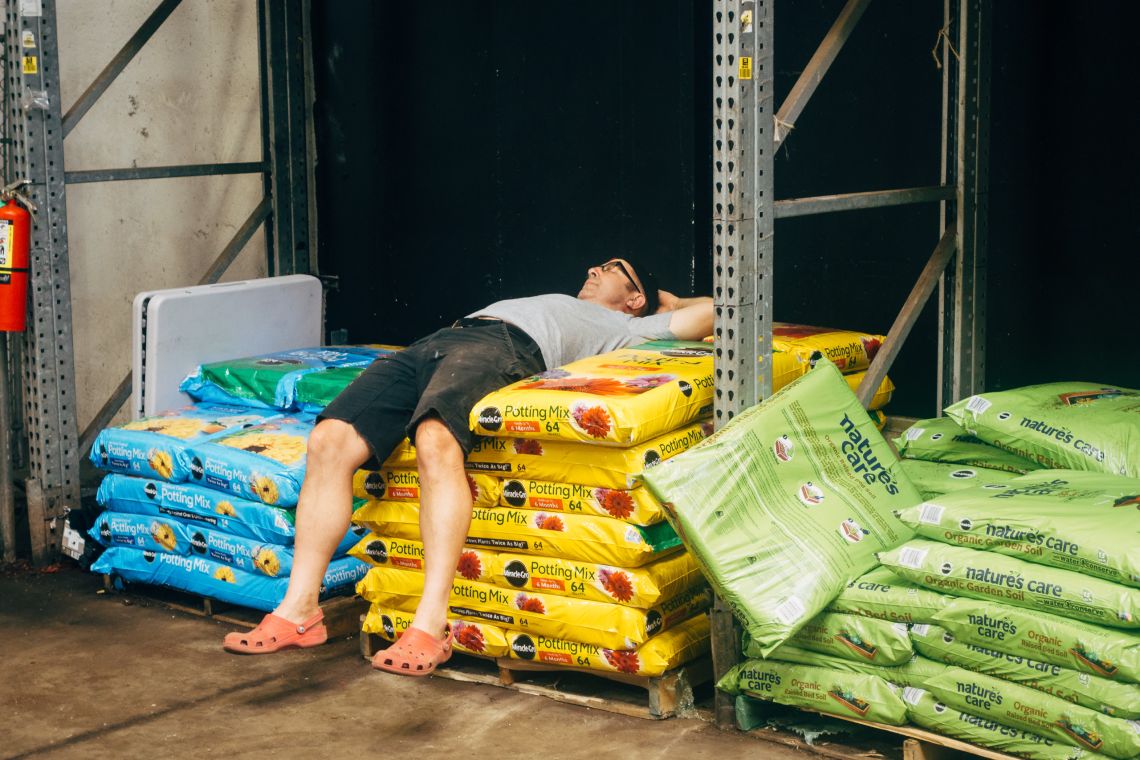 A man rests on a pile of potting mix