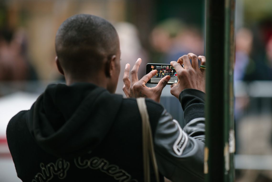 Man documenting the May Day March long 2nd Avenue