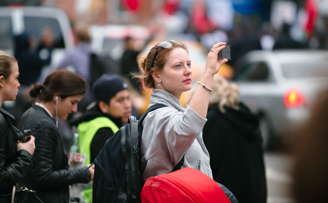 Man documenting the May Day March long 2nd Avenue