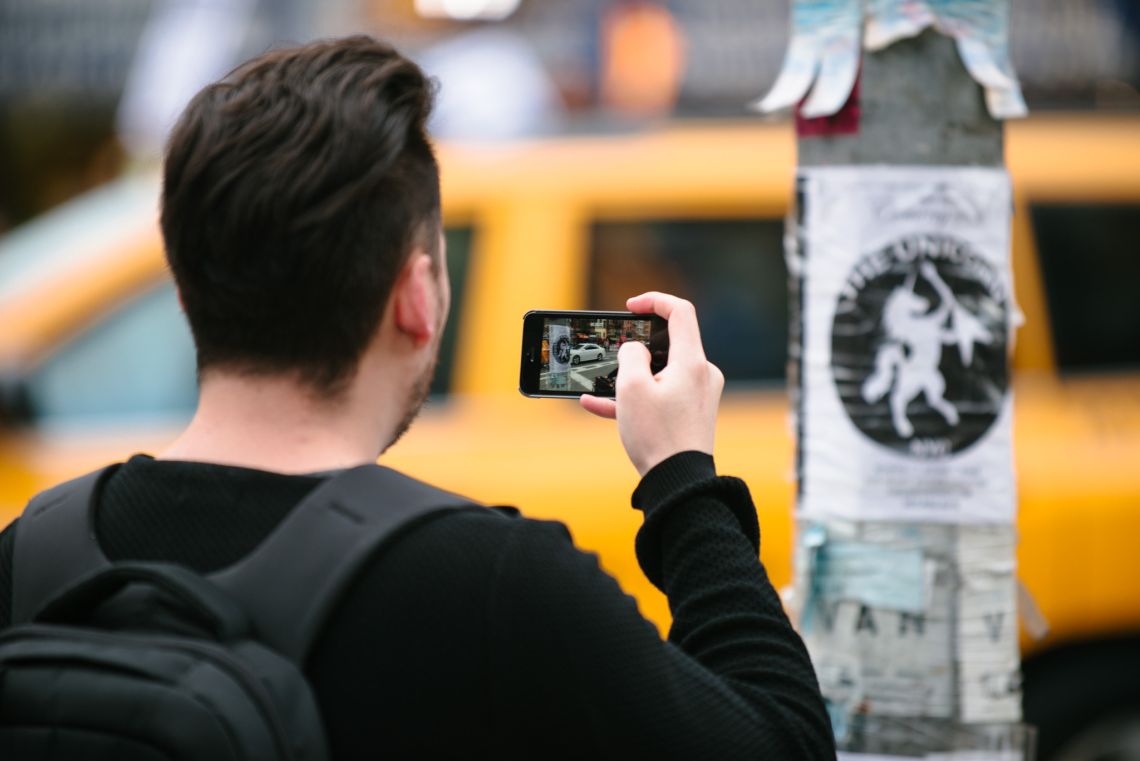 Man documenting the May Day March long 2nd Avenue