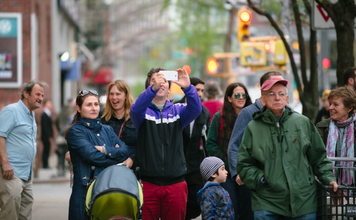 Man documenting the May Day March long 2nd Avenue
