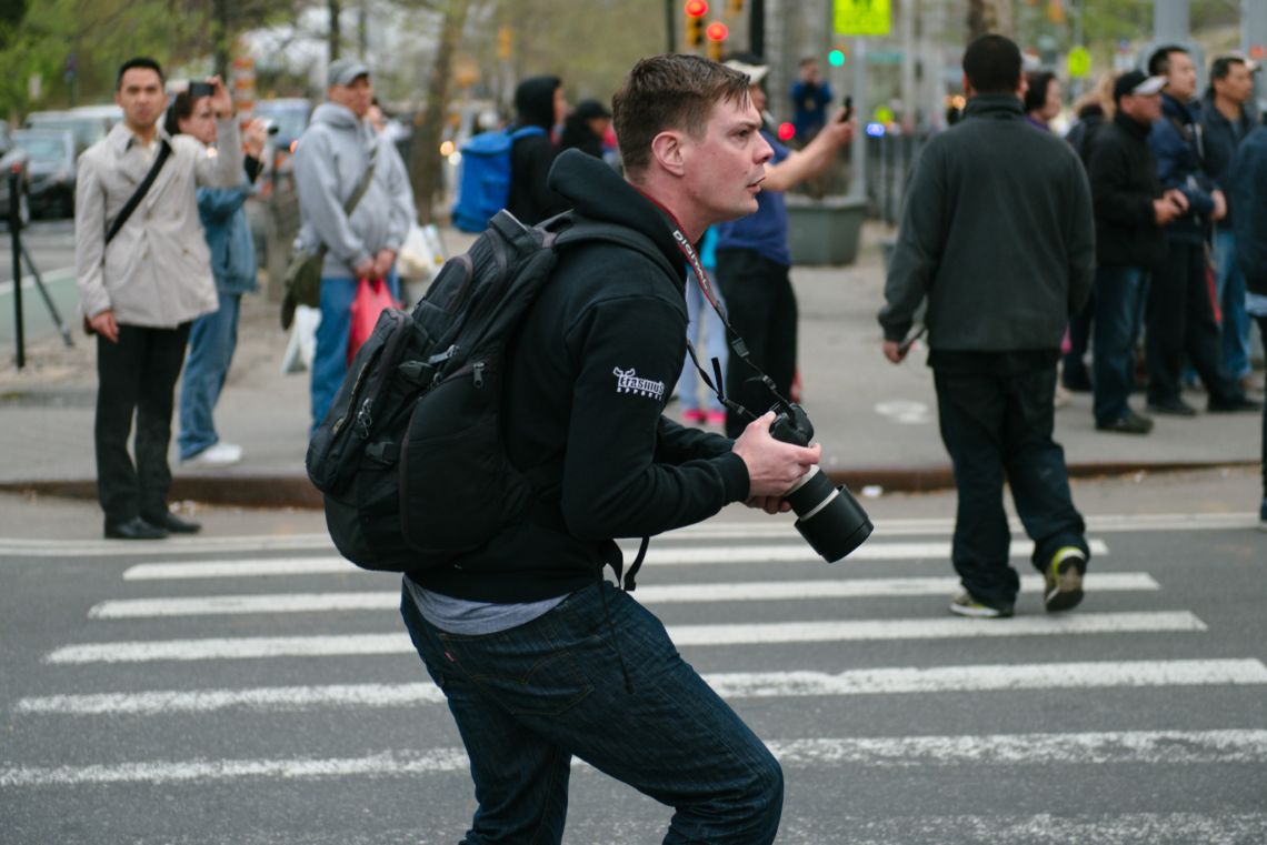 Man documenting the May Day March long 2nd Avenue