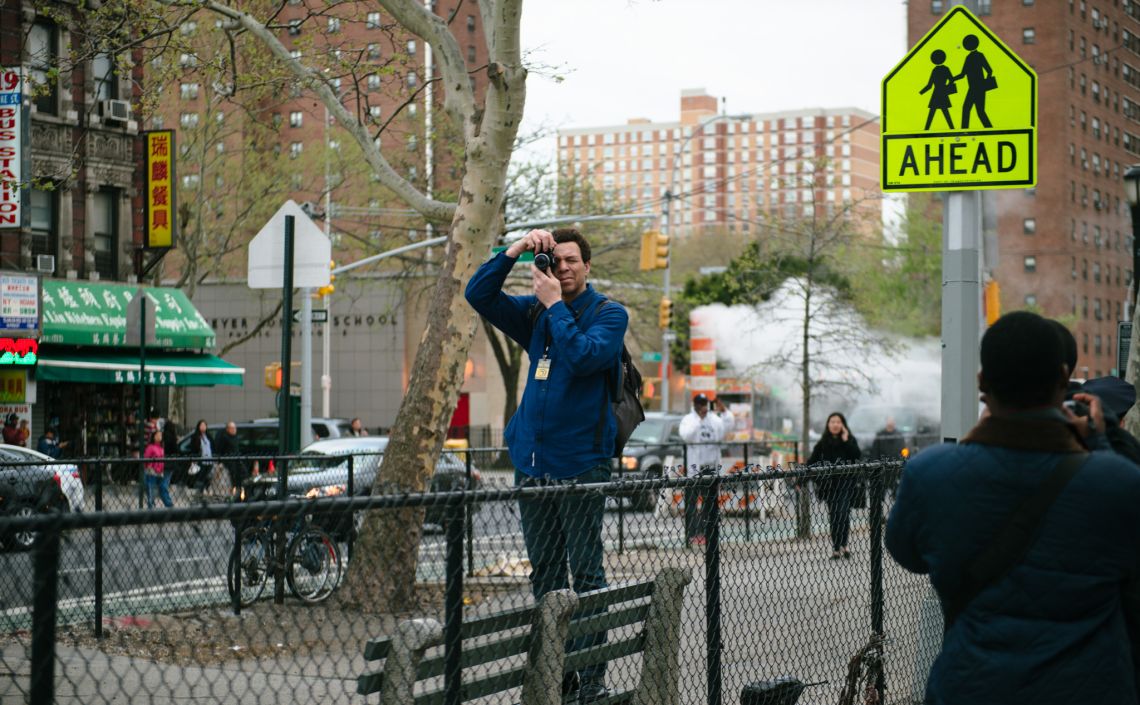 Man documenting the May Day March long 2nd Avenue