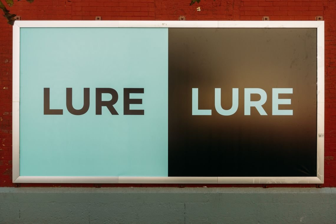 A street level &quot;Lure&quot; sign on a wall in Hudson Square