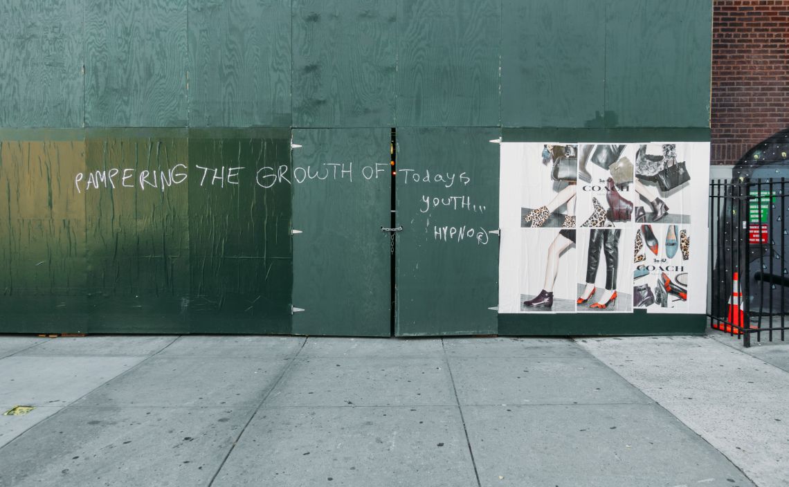 Signage and scrawl on a work site wall