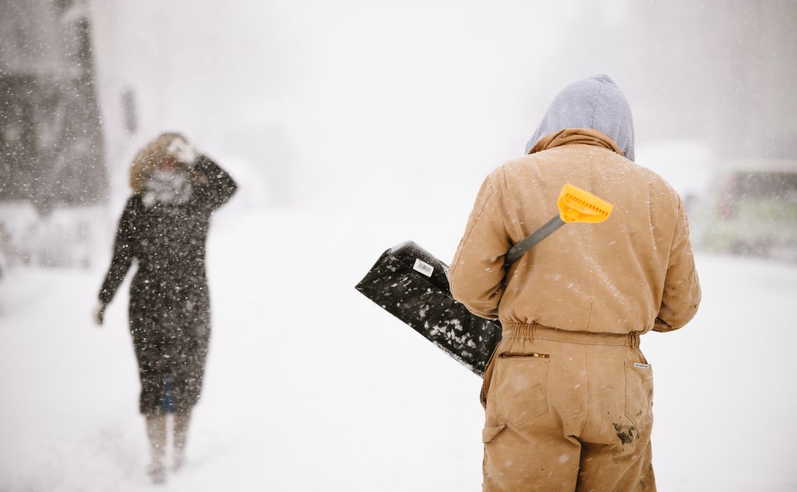 Snow removal laborer and pedestrian, Lexington Ave