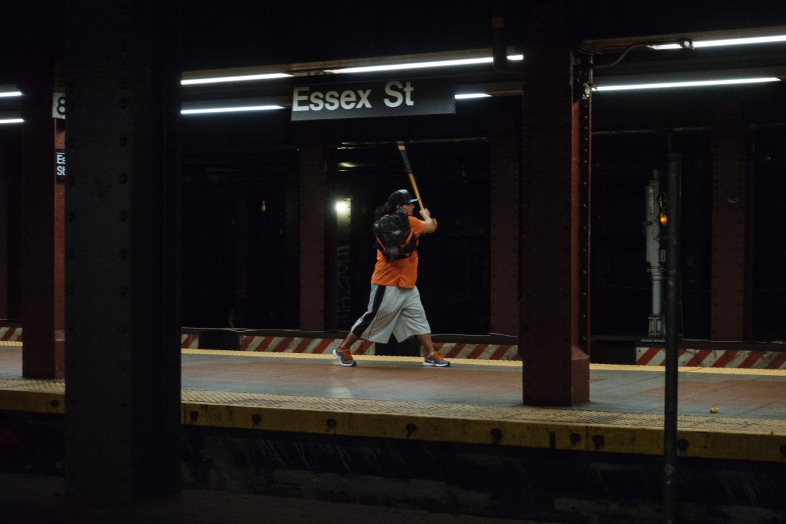 Man continues practicing batting swing with walking cane.