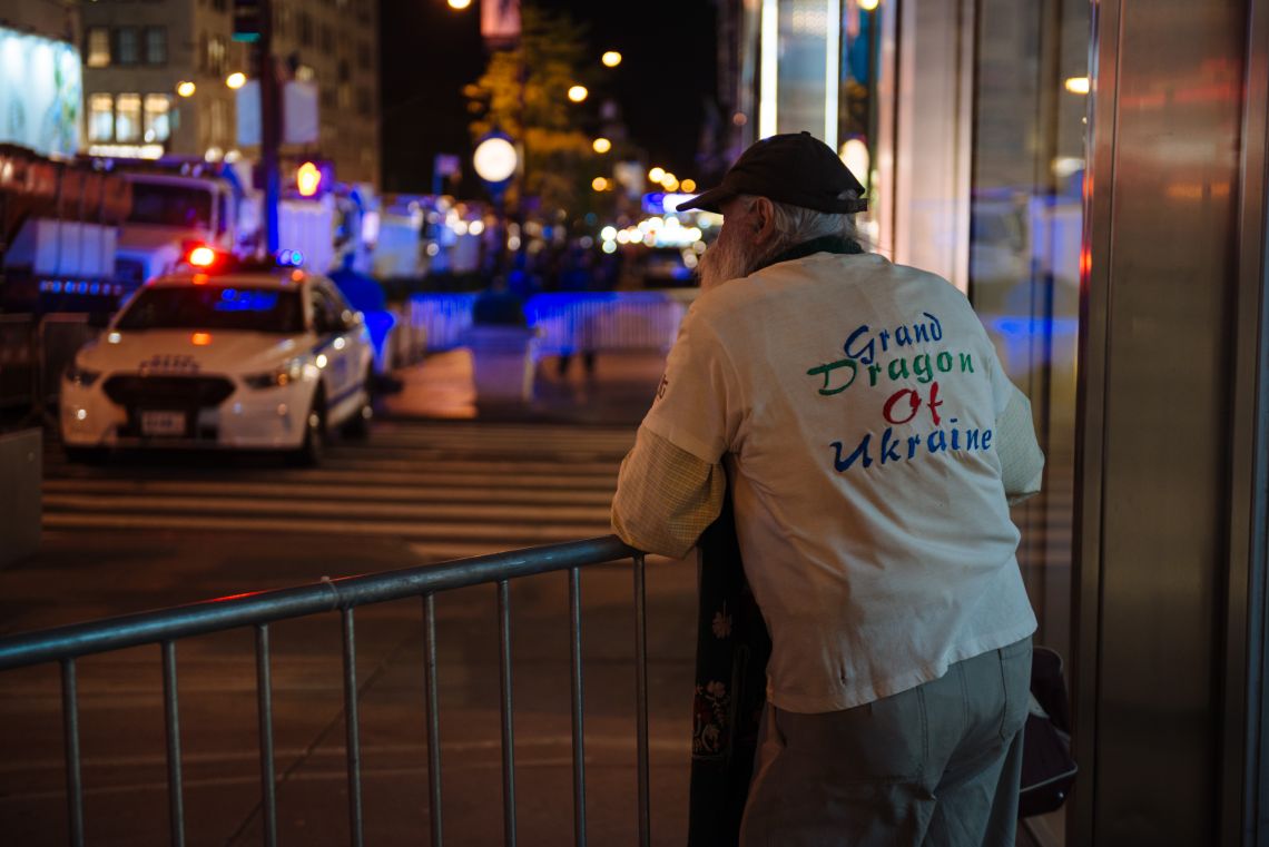 An old man in a Grand Dragon of Ukraine shirt stood along the barricade at Trump Tower