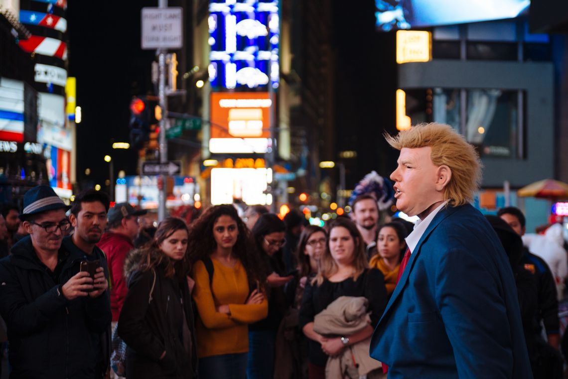 Women observe a Trump performer in Times Square