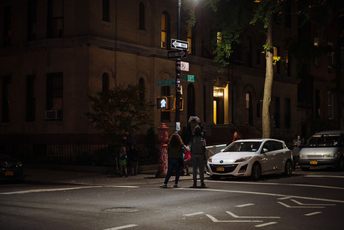 Passers-by took snapshots of the street signs at the intersection of Clinton and President