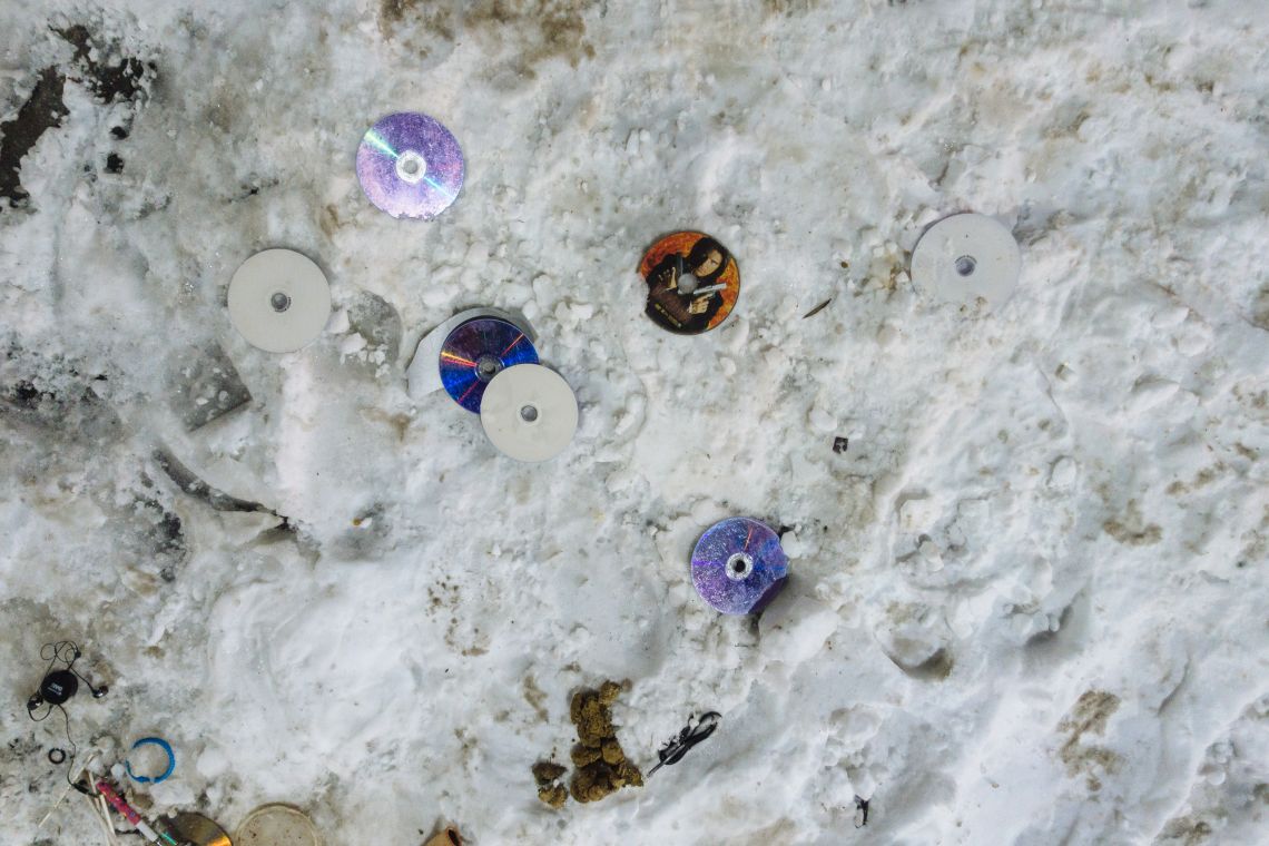DVDs and dog shit sit on the sidewalk